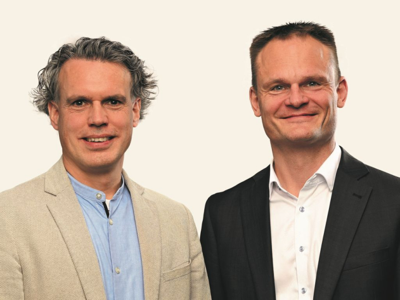 Die beiden Geschäftsführer Herr Dreißigacker, links im Bild, und Herr Pfeiffer, rechts, sind als Portrait abgebildet. Beide lächeln - zugewandt und freundlich - in die Kamera.