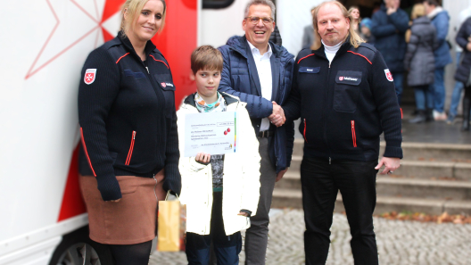 Auf dem Foto von links zu erkennen sind Mike Bleiser und Isabell Maczkowicz, die beiden ehrenamtlichen Mitarbeiter des Wärmemobils sowie der 11jährige Michel mit dem Scheck in der Hand  und Johannes Brumm, Geschäftsführer des St. Marienstiftes.